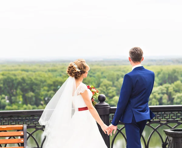 Gelin ve damat dışarıda el ele tutuşuyorlar..