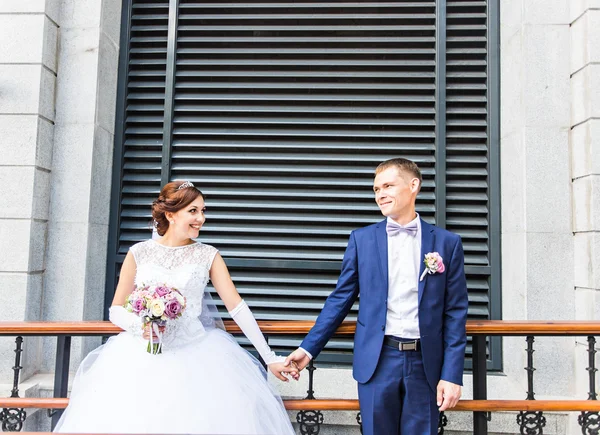 Bride and groom holding hands outdoors. — Stock Photo, Image