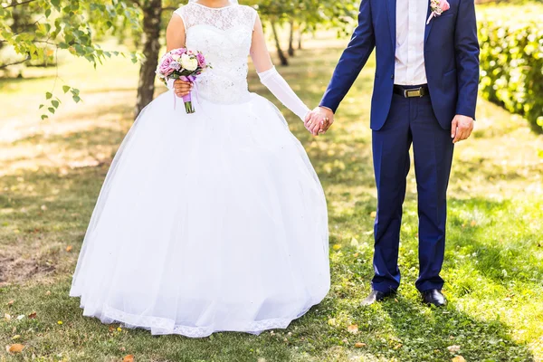 Mariée et marié tenant la main à l'extérieur . — Photo