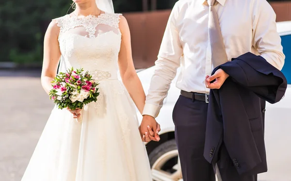 Thème de mariage, tenant les mains jeunes mariés — Photo