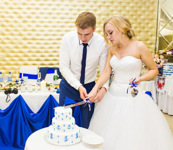 Schoonheid bruid en knappe bruidegom snijden een bruidstaart. — Stockfoto