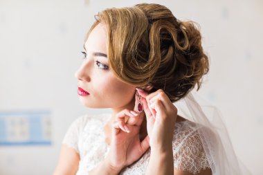 Hazırlık küpe portre üzerinde koyarak güzel zarif gelin evlilik.