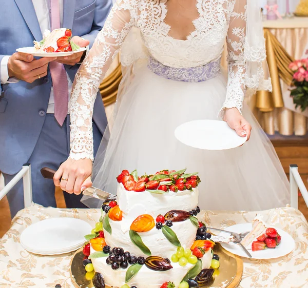 Braut und Bräutigam schneiden Hochzeitstorte — Stockfoto