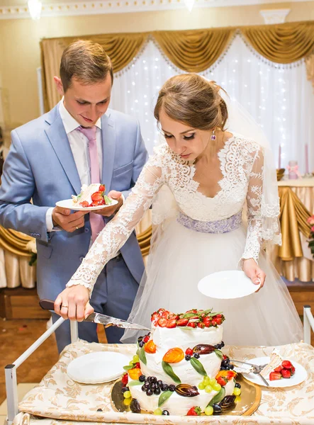 Panna młoda i pan młody kroją tort weselny. — Zdjęcie stockowe