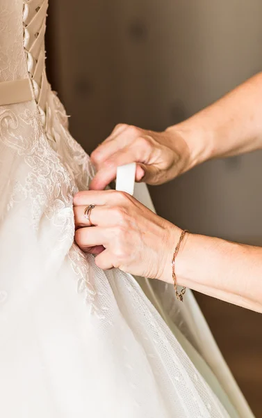 Bridesmaid is helping the bride to dress — Stock Photo, Image