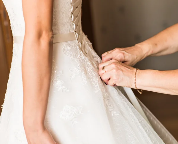 Dama de honor está ayudando a la novia a vestirse —  Fotos de Stock