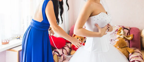 Damigella d'onore sta aiutando la sposa a vestirsi — Foto Stock