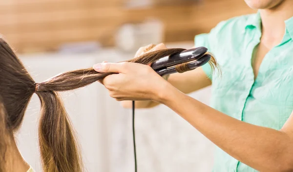 Cabelo curling estilista para mulher jovem. Menina se preocupa com seu penteado — Fotografia de Stock