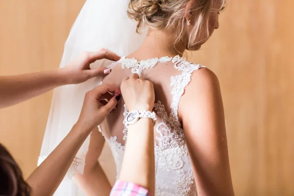 Dama de honor está ayudando a la novia a vestirse —  Fotos de Stock