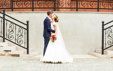 Güzel romantik gelin ile damat öpüşme ve açık havada kucaklayan