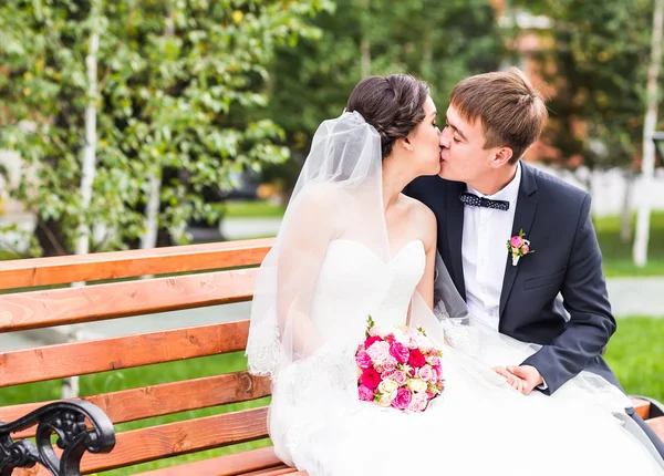 Groom kissing bride outdoors — Stock Photo, Image