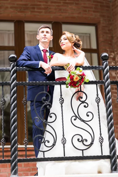 Noiva e noivo no dia do casamento andando ao ar livre. Feliz abraço dos recém-casados. Casal amoroso . — Fotografia de Stock