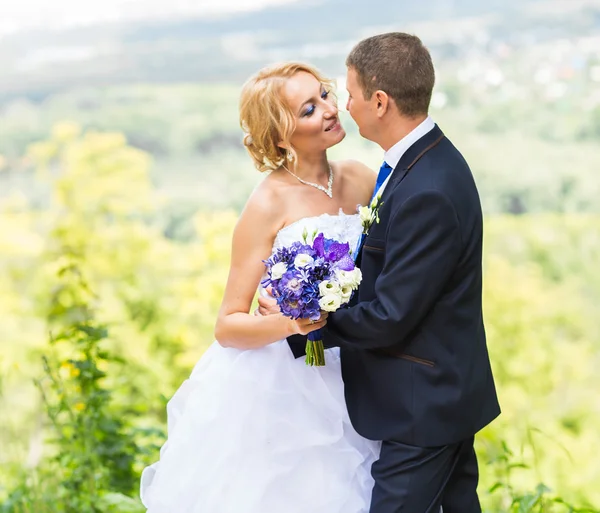Bruid en bruidegom op de bruiloft dag buiten lopen. Gelukkig jonggehuwden omarmen. Verliefde paar. — Stockfoto