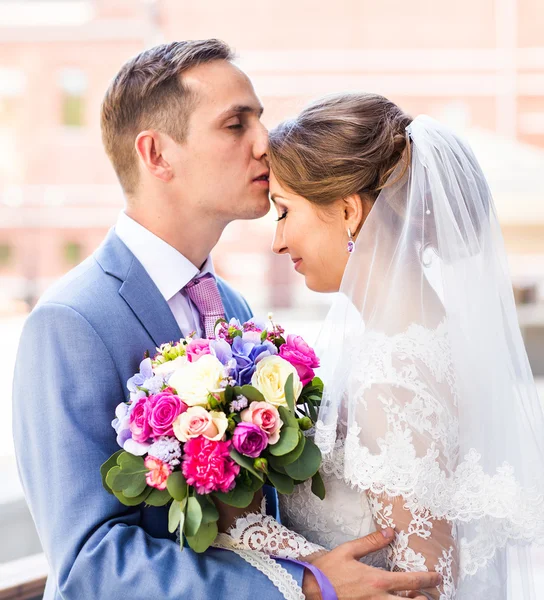 Novia y novio en el día de la boda caminando al aire libre. Recién casados felices abrazándose. Pareja amorosa . — Foto de Stock