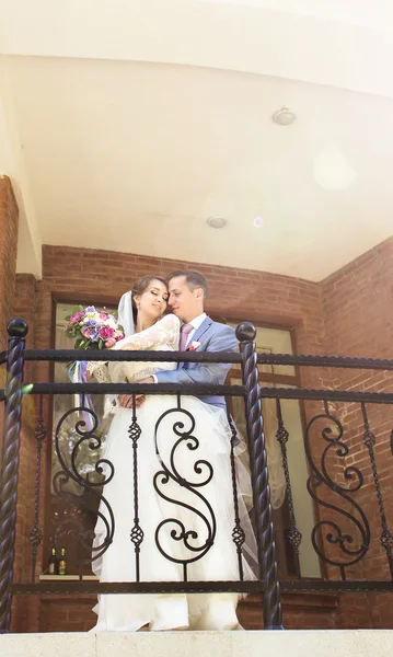 Весілля пара обіймає, наречена тримає букет квітів, наречений обіймає її на відкритому повітрі — стокове фото