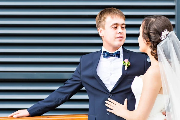 Novia y novio en el día de la boda caminando al aire libre. Recién casados felices abrazándose. Pareja amorosa . — Foto de Stock