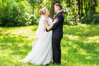 Gelin ve damat gün açık havada yürüyüş düğününde. Mutlu yeni evliler kucaklayan. Seven Çift.