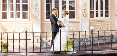 Onu açık havada kucaklayan Düğün çifti, sarılma bir buket çiçek, holding gelin damat