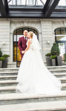 Onu açık havada kucaklayan Düğün çifti, sarılma bir buket çiçek, holding gelin damat