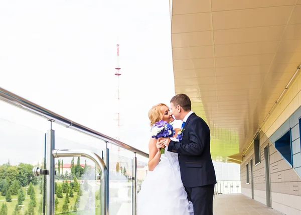 Mooie bruid en bruidegom omarmen op hun trouwdag buitenshuis — Stockfoto