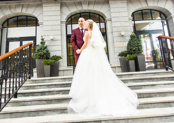 Novia y novio en el día de la boda caminando al aire libre. Recién casados felices abrazándose. Pareja amorosa . —  Fotos de Stock