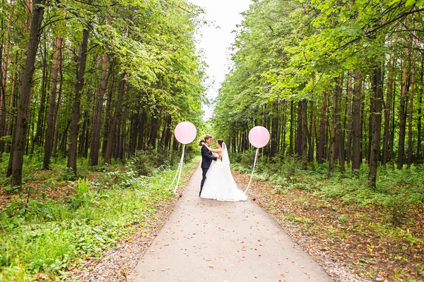 Прекрасные невеста и жених обнимаются в день своей свадьбы на открытом воздухе — стоковое фото