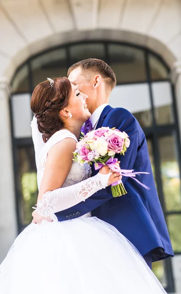 Vackra bruden och brudgummen embracing på deras bröllopsdag utomhus — Stockfoto
