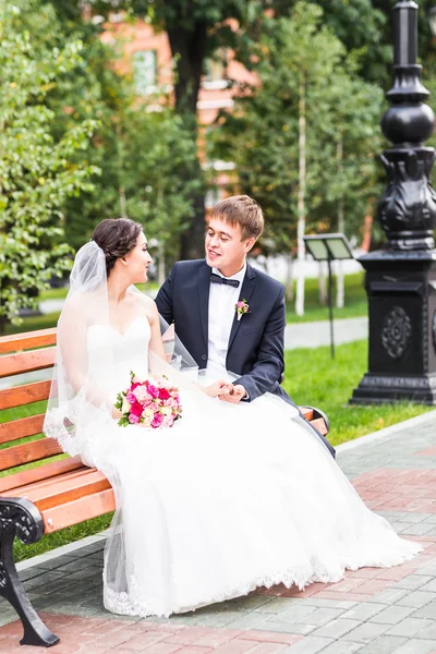 Vackra bruden och brudgummen embracing på deras bröllopsdag utomhus — Stockfoto