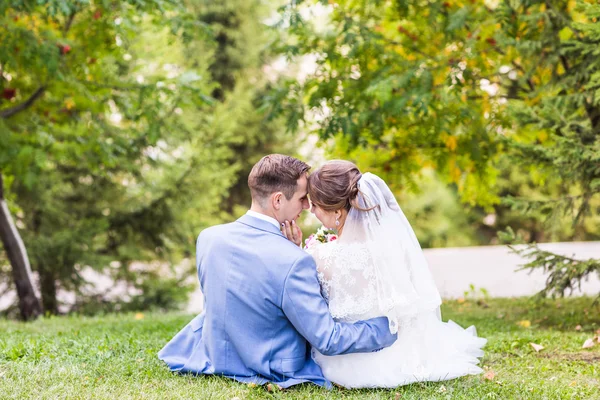 Hermosa novia y novio abrazando en su boda al aire libre — Foto de Stock