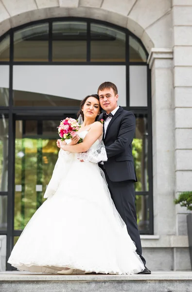 Hermosa novia y novio abrazando en su boda al aire libre — Foto de Stock