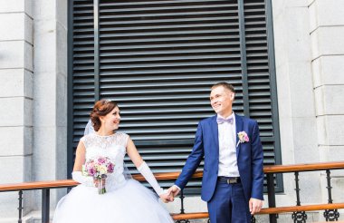 Gelin ve damat dışarıda el ele tutuşuyorlar..