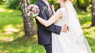 sarılma, elinde bir buket çiçek, onu kucaklayan damat gelin düğün çifti