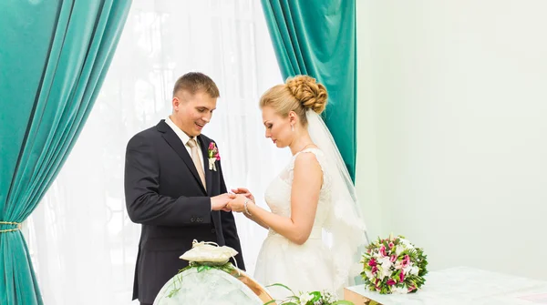 Bride slipping ring on finger of groom at wedding — Stock Photo, Image