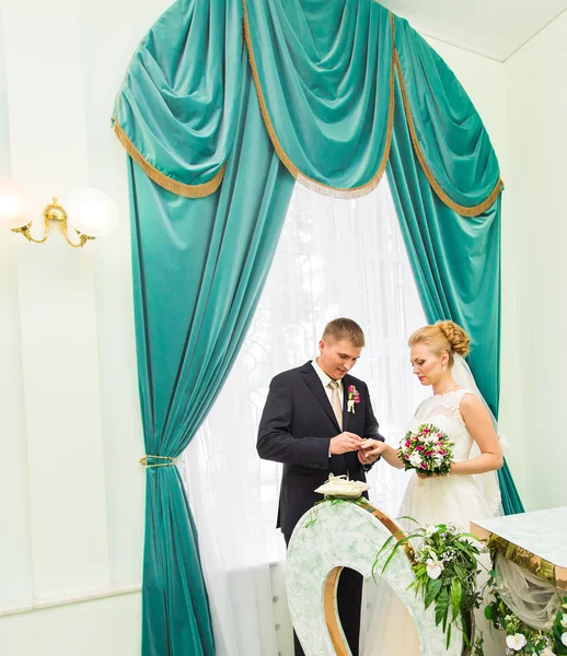 Groom slipping ring on finger of bride at wedding — Stock Photo, Image