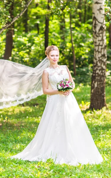 Mooie bruid met boeket van bloemen buiten — Stockfoto