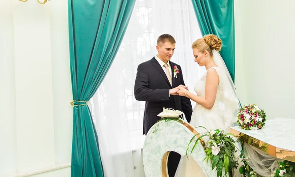 Наречена ковзає кільце на пальці нареченого на весіллі — стокове фото