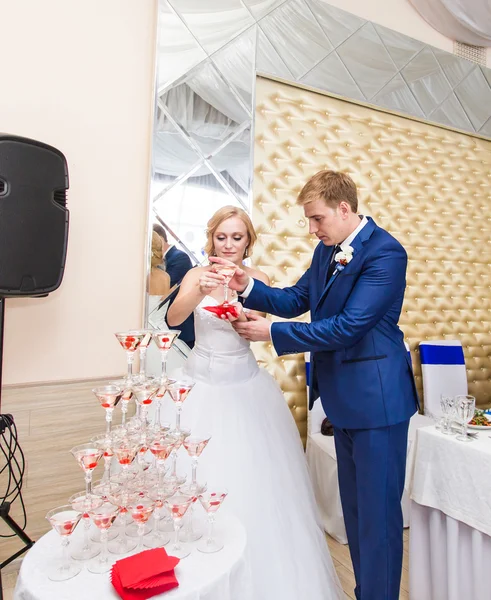 Brudgummen häller champagne i glaset. — Stockfoto