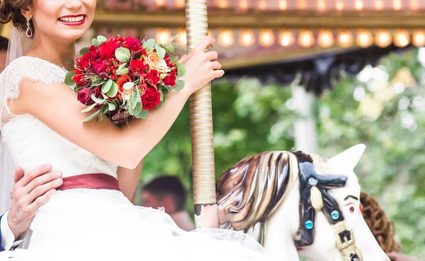 Bruid en bruidegom op carrousel — Stockfoto