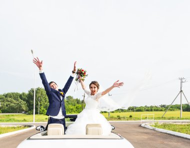 Damat ve gelin beyaz bir Cabrio araba