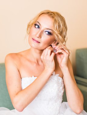 Hazırlık küpe portre üzerinde koyarak güzel zarif gelin evlilik.