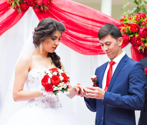 Bruidegom zet trouwring op bruid hand — Stockfoto