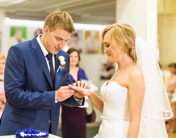 Наречений ковзає кільце на пальці нареченої на весіллі — стокове фото