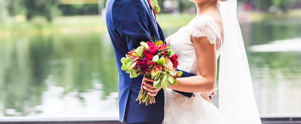 Bruid en bruidegom op hun trouwdag buitenshuis — Stockfoto