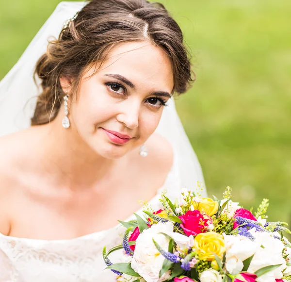 Gyönyörű menyasszony, esküvői csokor virágot, szabadban, park. — Stock Fotó