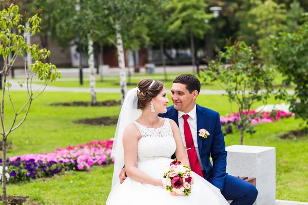 Hermosa novia y novio abrazando en su boda al aire libre — Foto de Stock