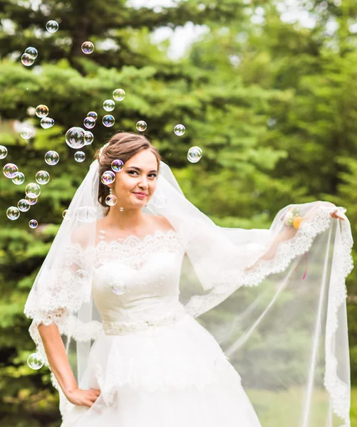 Jovem noiva brincar com bolha de sabão e alegria sorriso — Fotografia de Stock