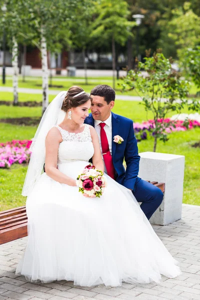 Hermosa novia y novio abrazando en su boda al aire libre — Foto de Stock