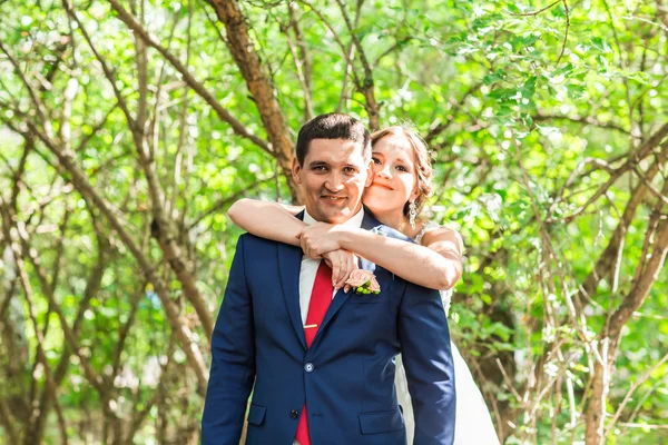 Hermosa novia y novio abrazando en su boda al aire libre — Foto de Stock