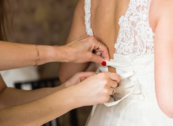 Dama de honor está ayudando a la novia a vestirse —  Fotos de Stock