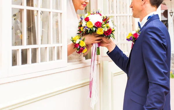 Handsome groom giving hand to beautiful bride — Stock Photo, Image